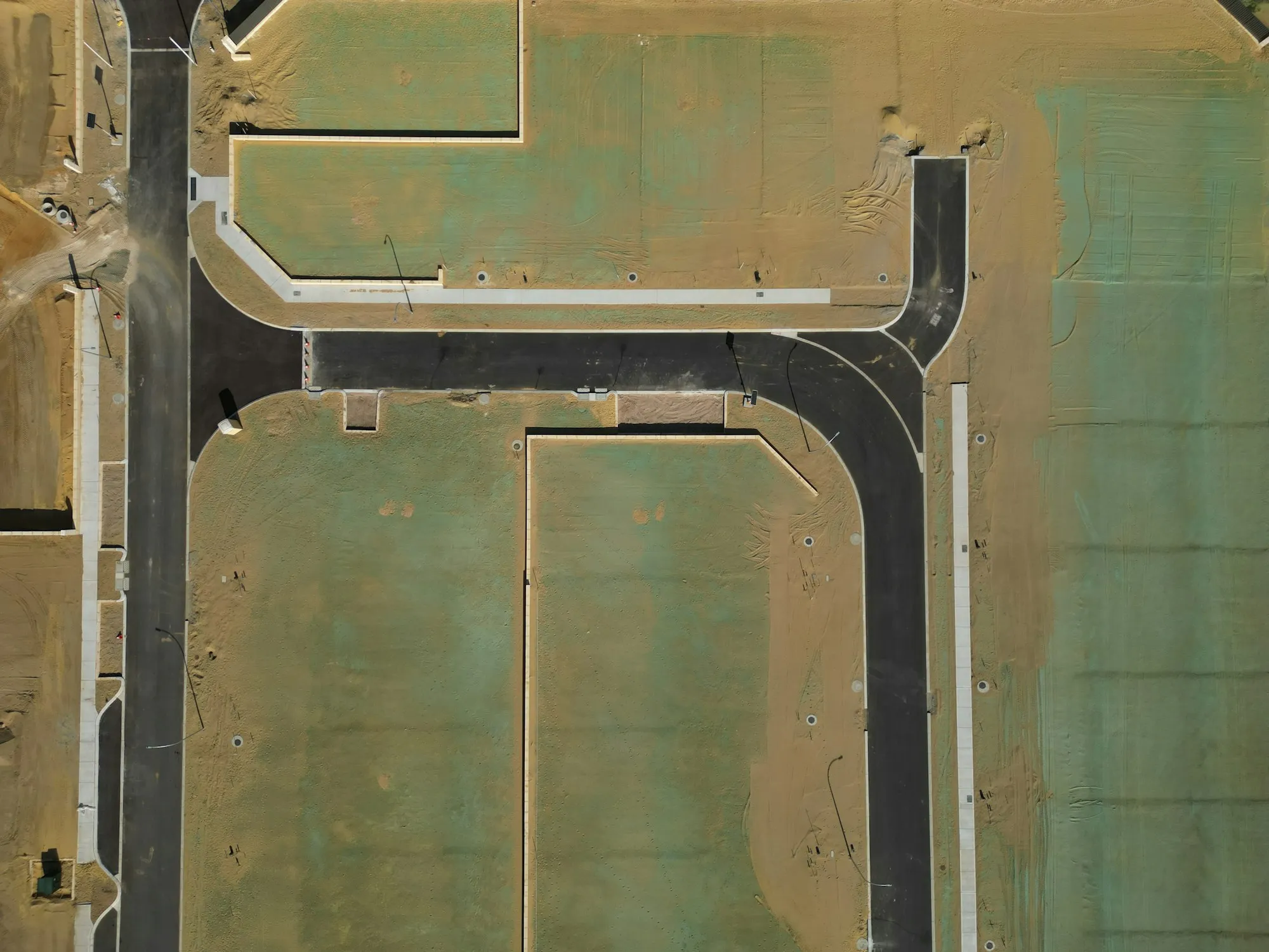Aerial view of graded parcels and new roads at a master-planned site before construction